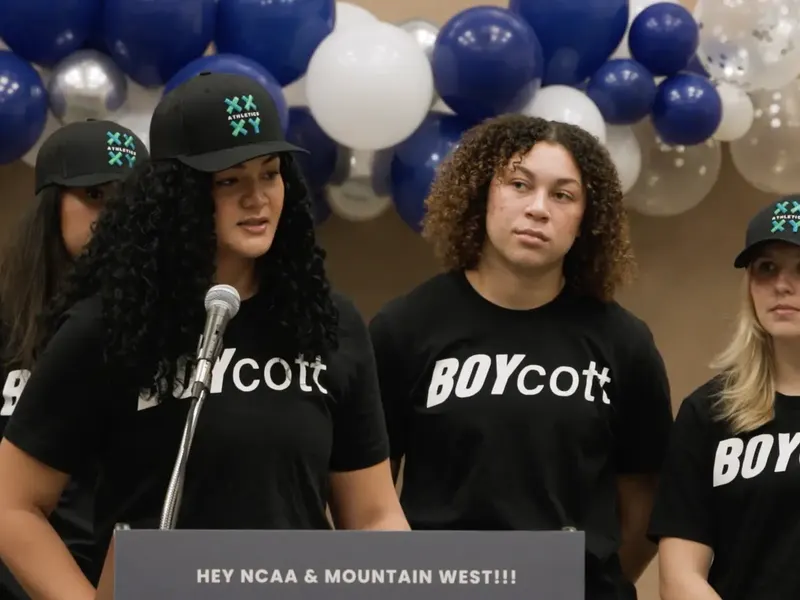 Volleyball players in BOYcott shirts at a press conference