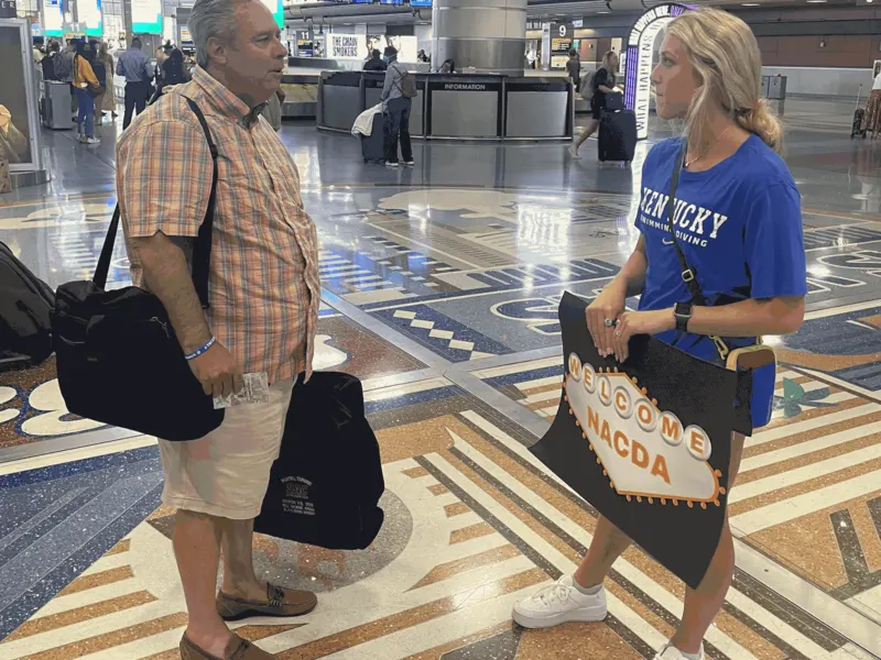 An ICONS athlete welcomes an athletic director at the Las Vegas airport