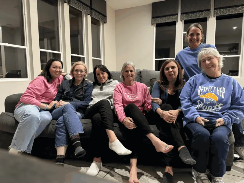 ICONS women together on a couch, in ICONS and Respect Her Sports shirts